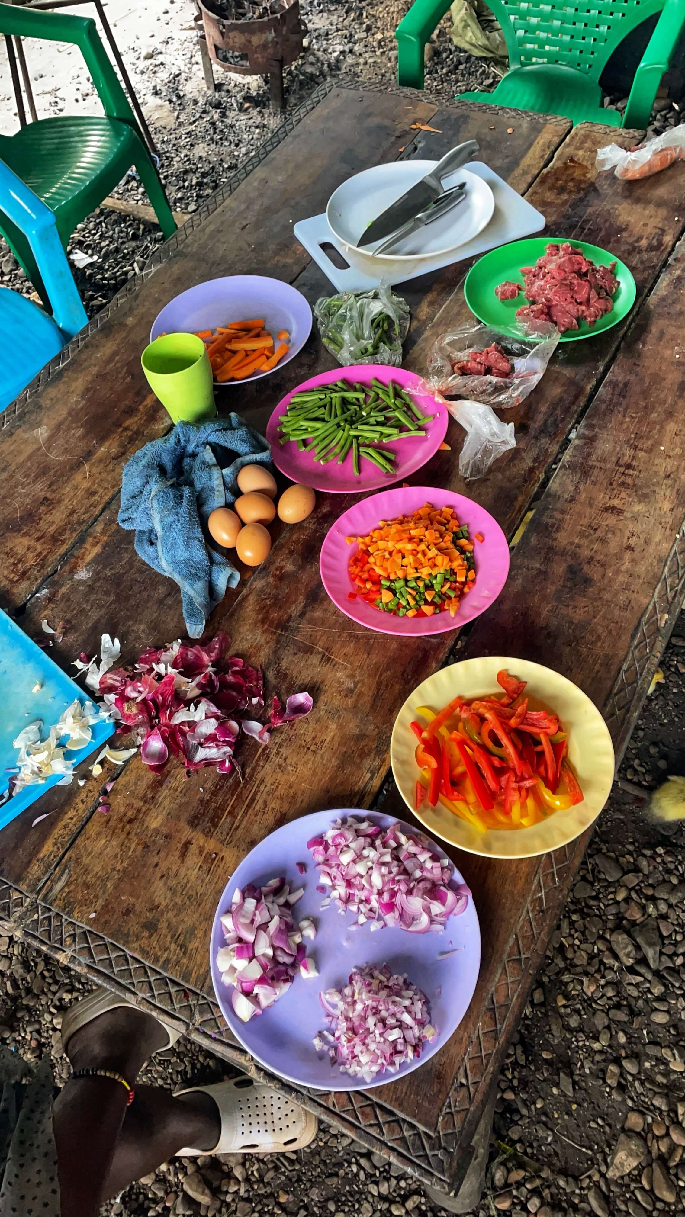 Colorful plates with diced onions, bell peppers, carrots, green beans and ground beef.